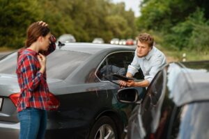 Male and female drivers on road, car accident